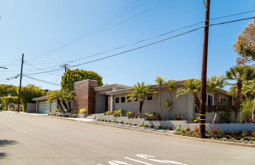 Inspiration for a mid-sized 1950s gray split-level stucco exterior home remodel in Los Angeles