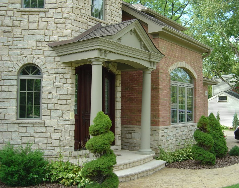 Esempio della facciata di una casa beige classica a piani sfalsati con rivestimento in pietra