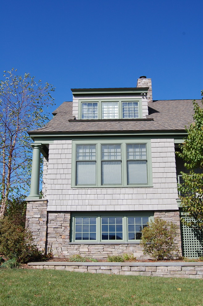 Photo of a large and gey traditional split-level house exterior in Bridgeport with concrete fibreboard cladding and a half-hip roof.