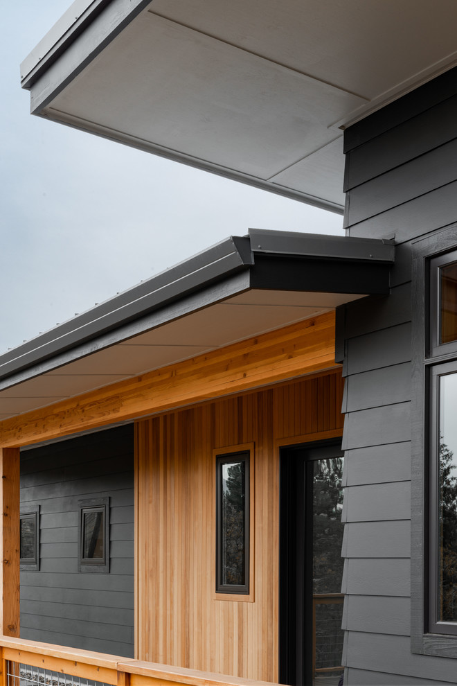 Idée de décoration pour une petite façade de maison multicolore design de plain-pied avec un revêtement mixte, un toit plat et un toit en métal.