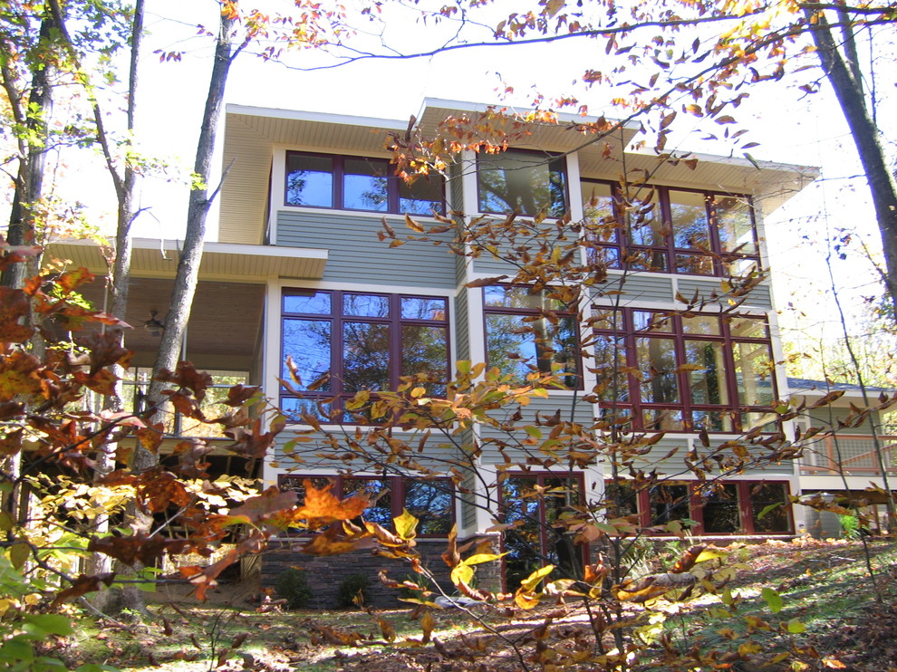 Immagine della facciata di una casa verde contemporanea a tre piani con rivestimento in vinile e tetto a padiglione
