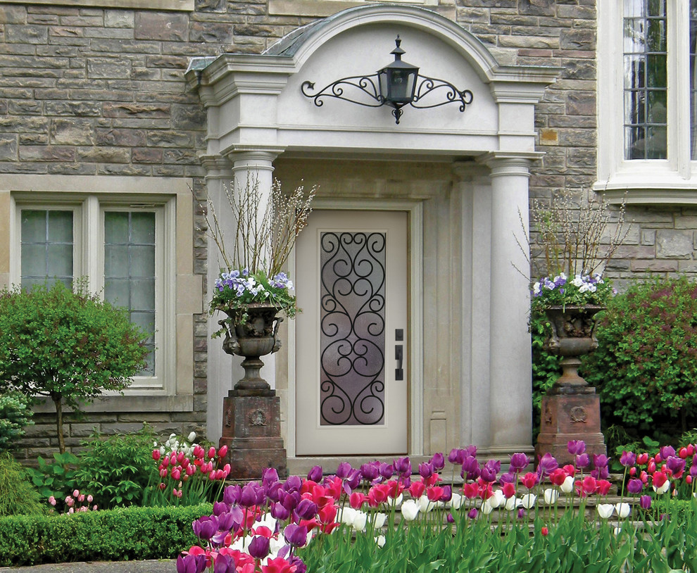 Пример оригинального дизайна: двухэтажный, серый дом среднего размера в викторианском стиле с облицовкой из камня