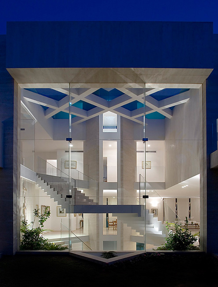 Bild på ett stort funkis hus, med två våningar och glasfasad
