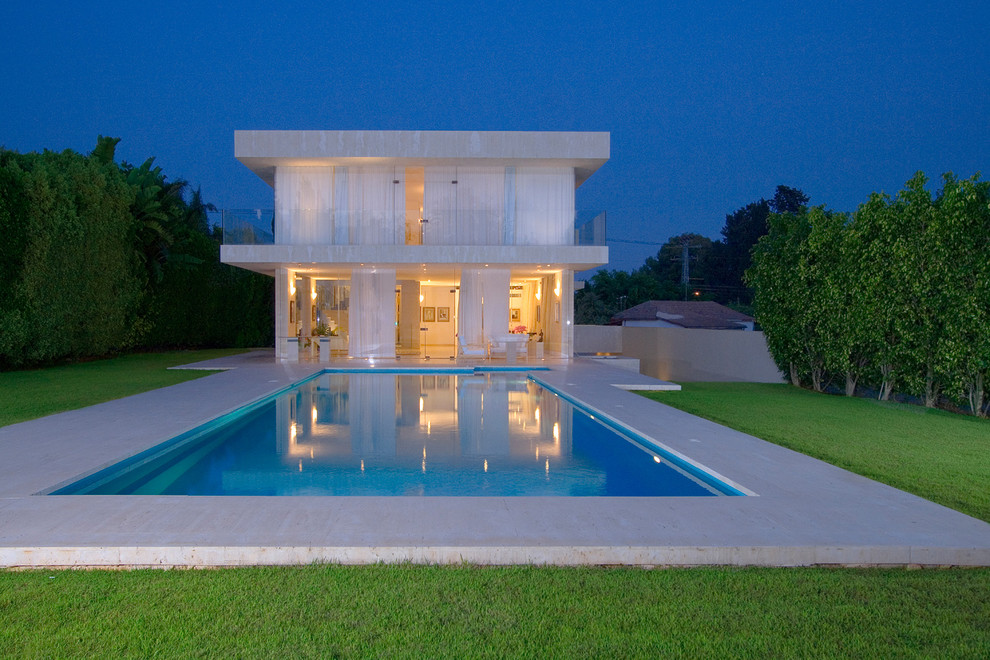 Réalisation d'une façade de maison minimaliste en verre de taille moyenne et à un étage.