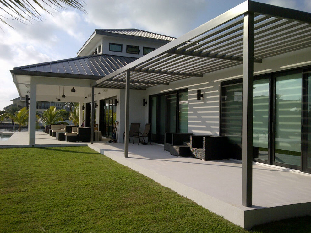 Ejemplo de fachada de casa beige costera extra grande de una planta con revestimientos combinados, tejado a cuatro aguas y tejado de metal