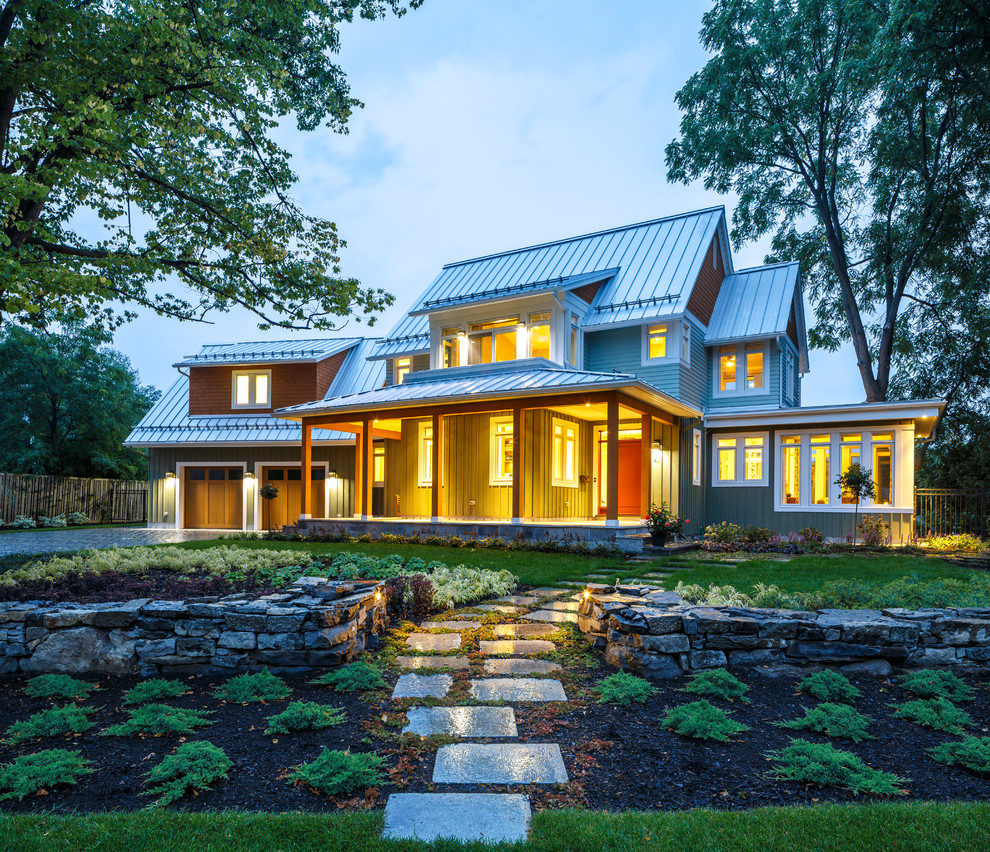Imagen de fachada de casa verde de estilo de casa de campo grande de dos plantas con revestimiento de madera, tejado a dos aguas y tejado de metal