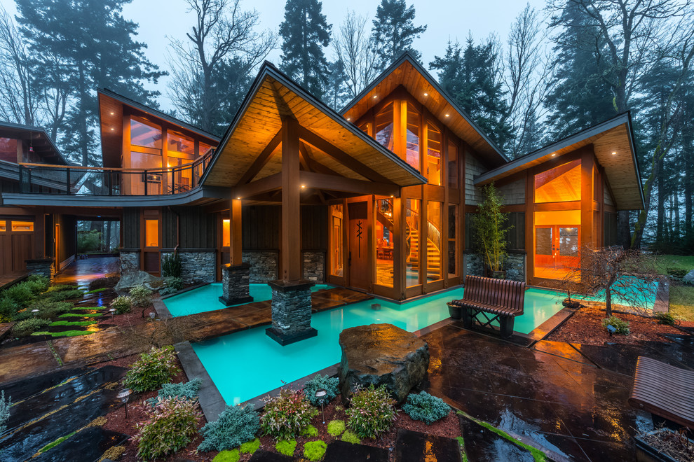 Design ideas for a large rustic two floor house exterior in Vancouver with mixed cladding and a lean-to roof.