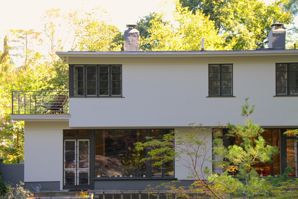 Modelo de fachada blanca minimalista de dos plantas con tejado plano