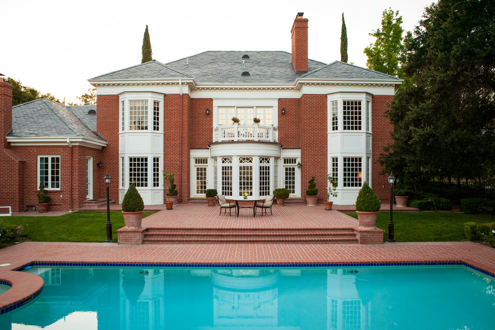 This is an example of a large and red classic two floor brick house exterior in San Diego.