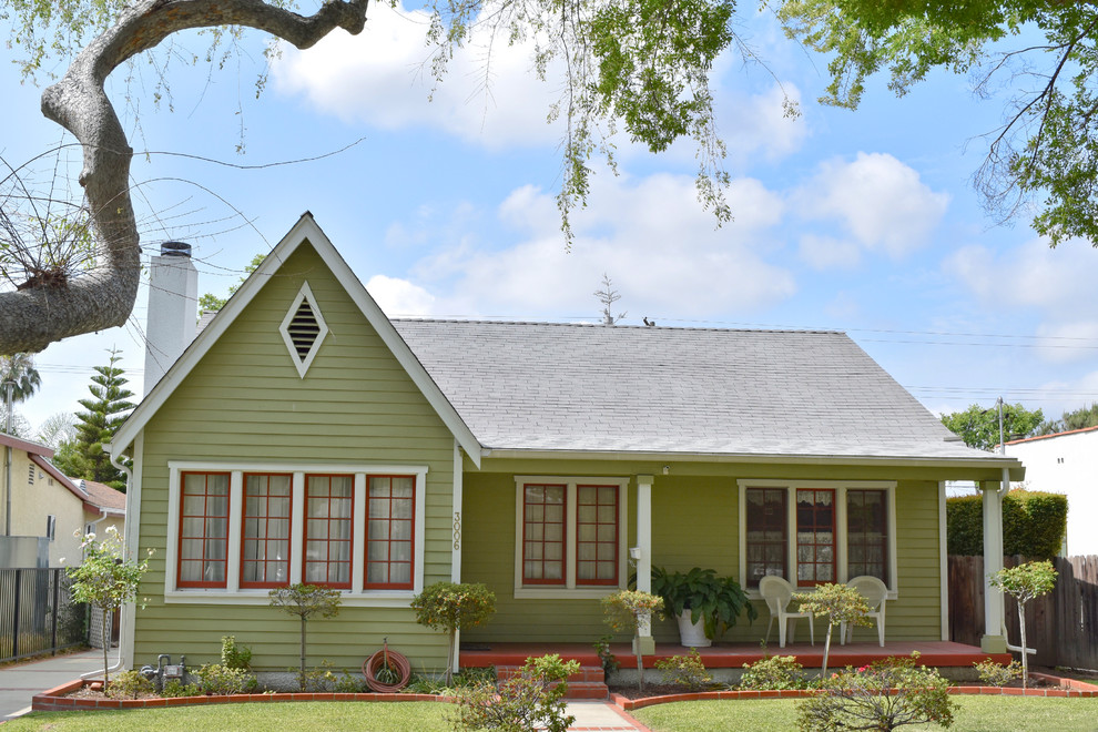 Immagine della facciata di una casa verde american style a un piano di medie dimensioni con rivestimento in legno e tetto a capanna