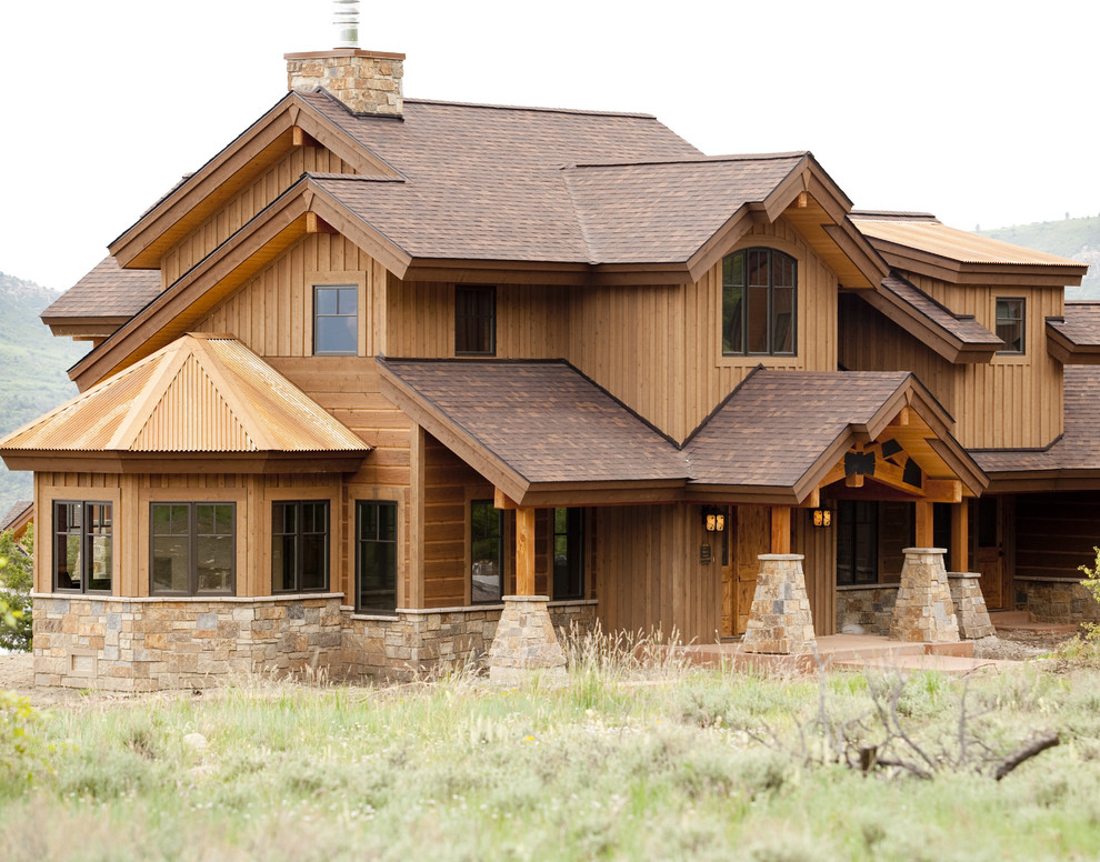 Стильный дизайн: деревянный, коричневый, двухэтажный, огромный частный загородный дом в классическом стиле с двускатной крышей и крышей из гибкой черепицы - последний тренд
