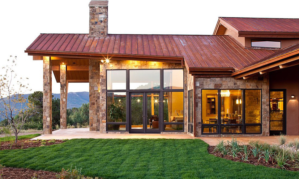 This is an example of a beige and expansive rustic two floor detached house in Denver with stone cladding, a pitched roof and a metal roof.