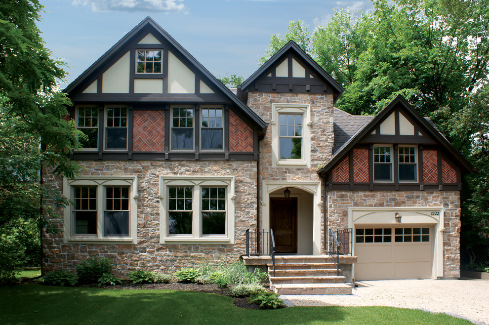 Immagine della facciata di una casa beige classica a due piani con rivestimento in pietra