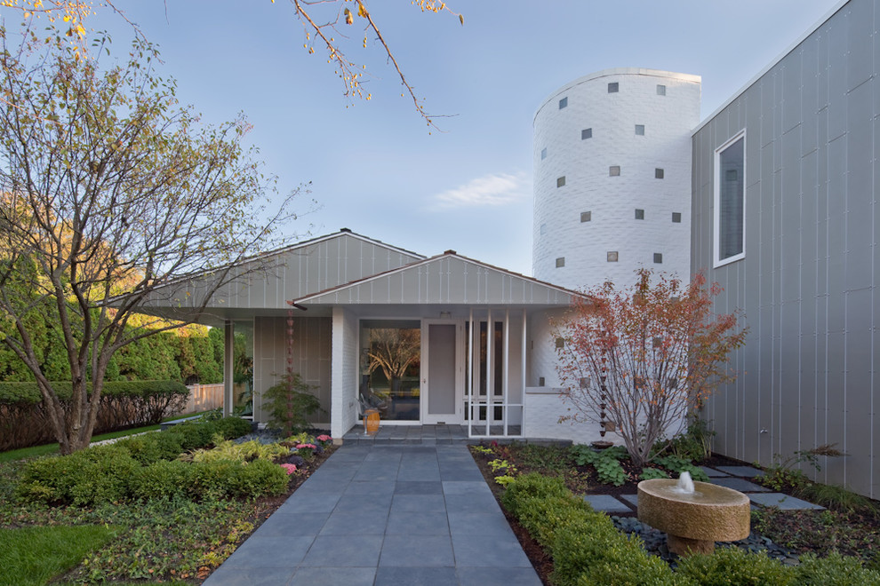 Idée de décoration pour une façade de maison grise minimaliste en panneau de béton fibré à un étage.