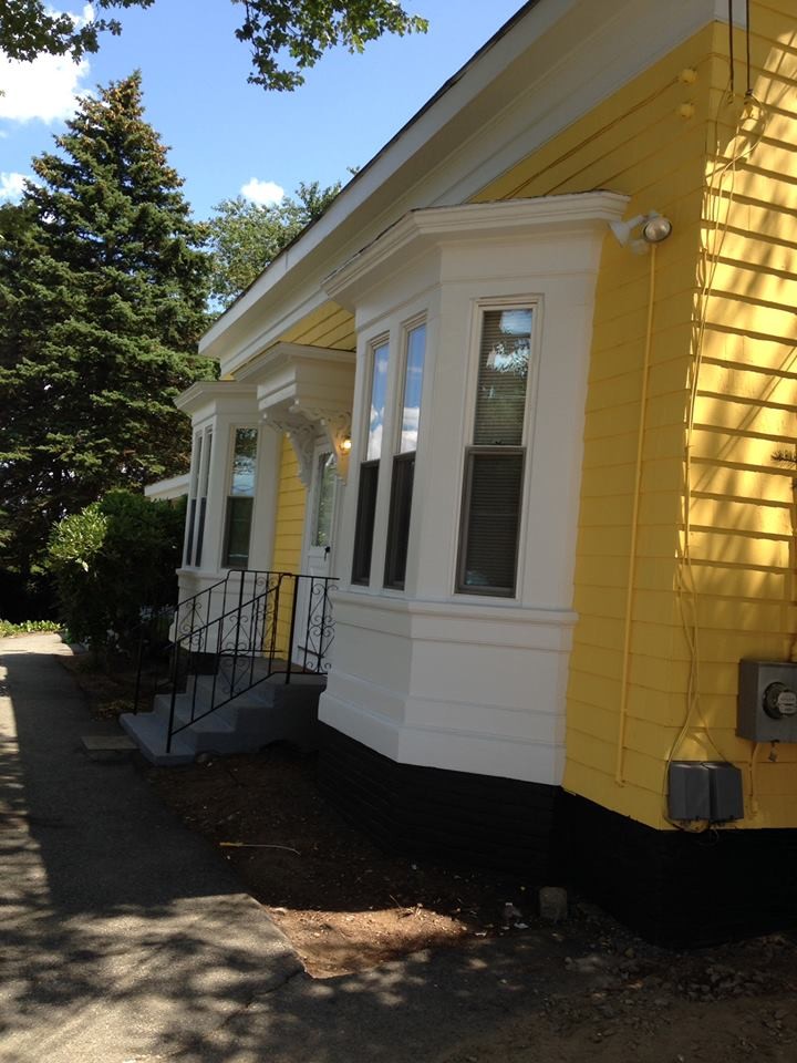 Foto della facciata di una casa gialla a due piani