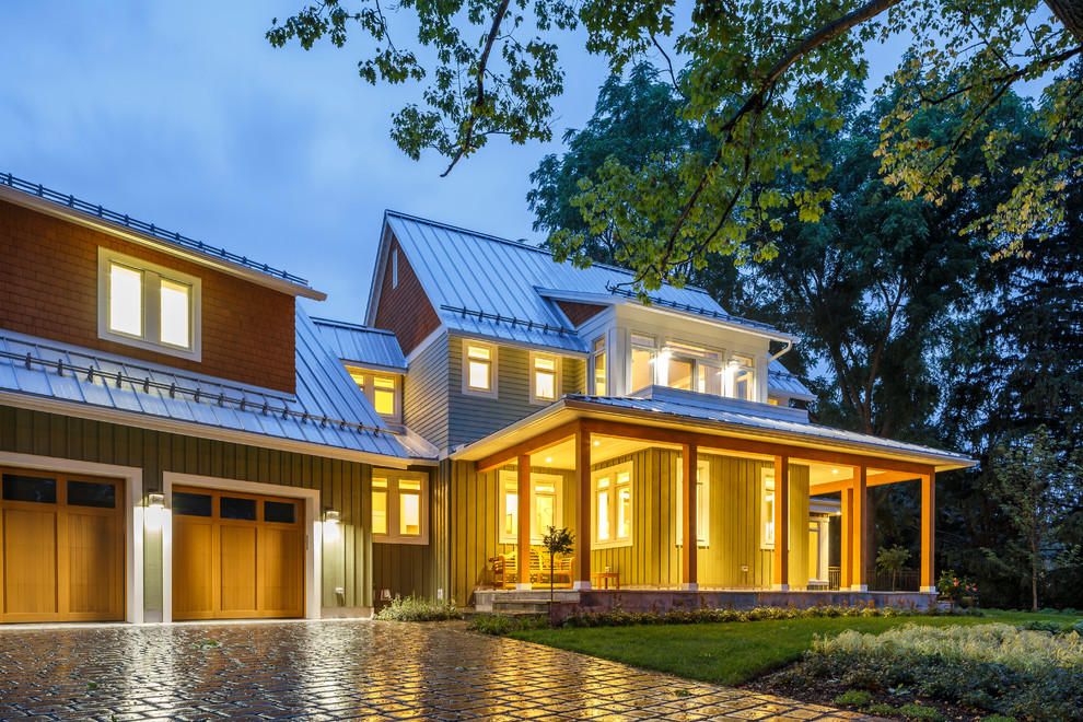 Aménagement d'une façade de maison verte campagne en bois de taille moyenne et à un étage avec un toit à deux pans et un toit en métal.