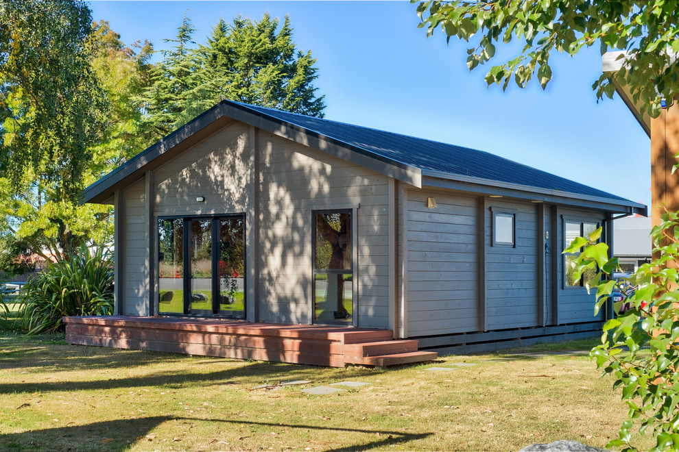 This is an example of a small and gey scandinavian bungalow detached house in Christchurch with wood cladding.