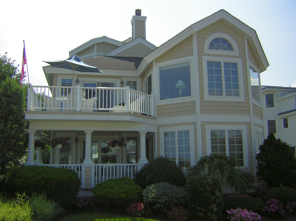 Immagine della facciata di una casa grande beige stile marinaro a due piani con rivestimento in legno e abbinamento di colori