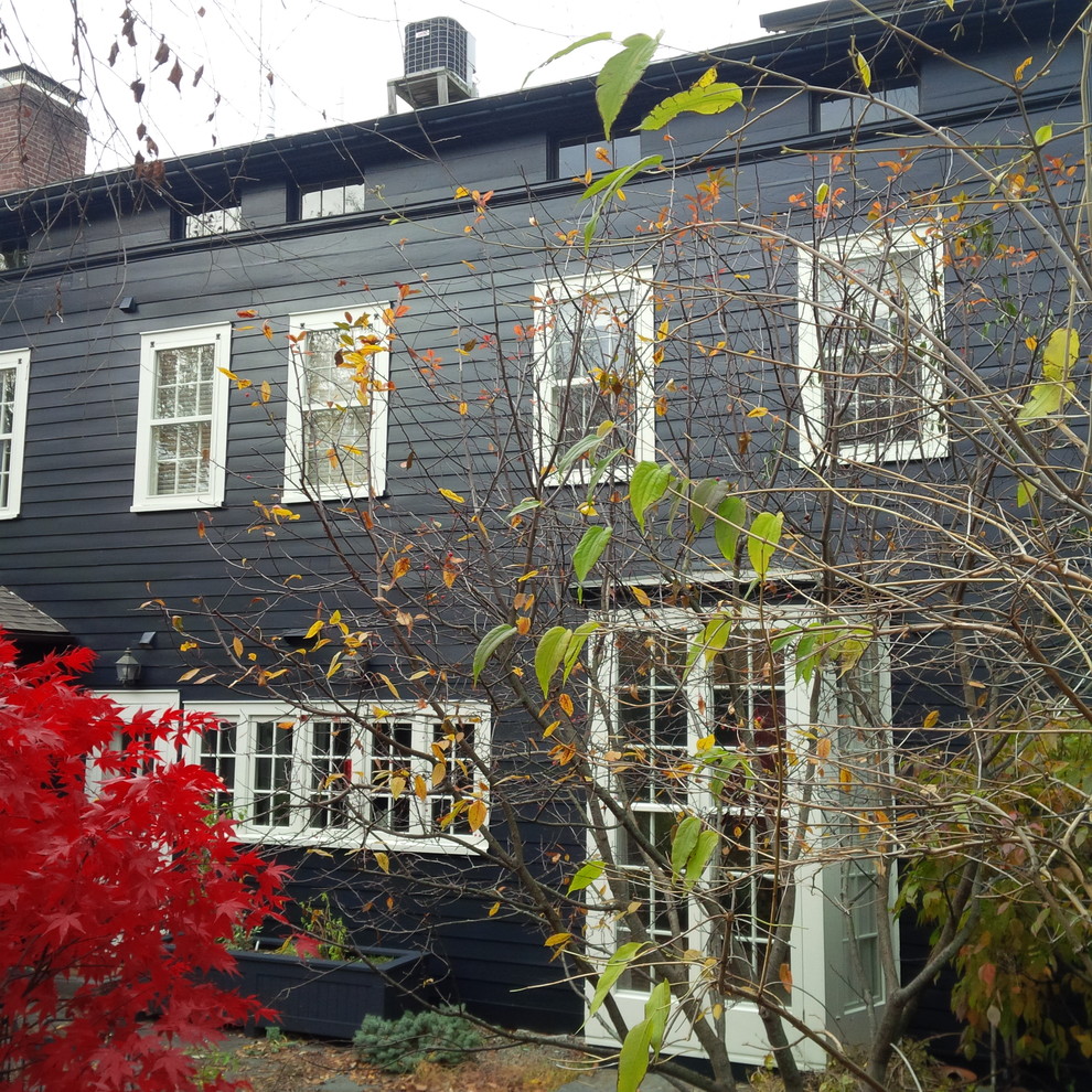 Photo of a black traditional two floor house exterior in Boston with wood cladding.