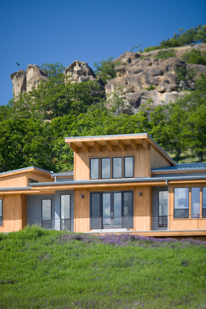 На фото: деревянный, огромный, разноцветный частный загородный дом в современном стиле с односкатной крышей и металлической крышей