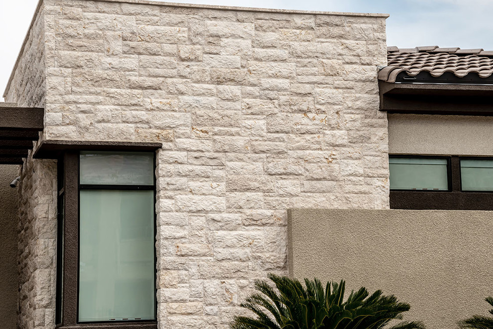 Foto della facciata di una casa grande bianca moderna a due piani con rivestimento in pietra