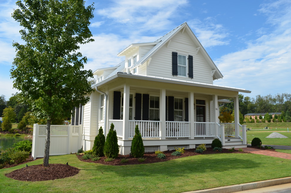 Cette image montre une petite façade de maison blanche traditionnelle à un étage avec un revêtement en vinyle et un toit à deux pans.