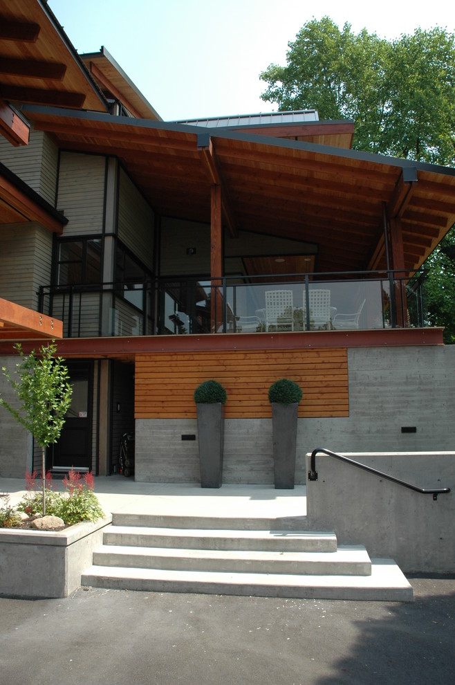 Ejemplo de fachada gris contemporánea grande de dos plantas con revestimiento de vidrio y tejado plano
