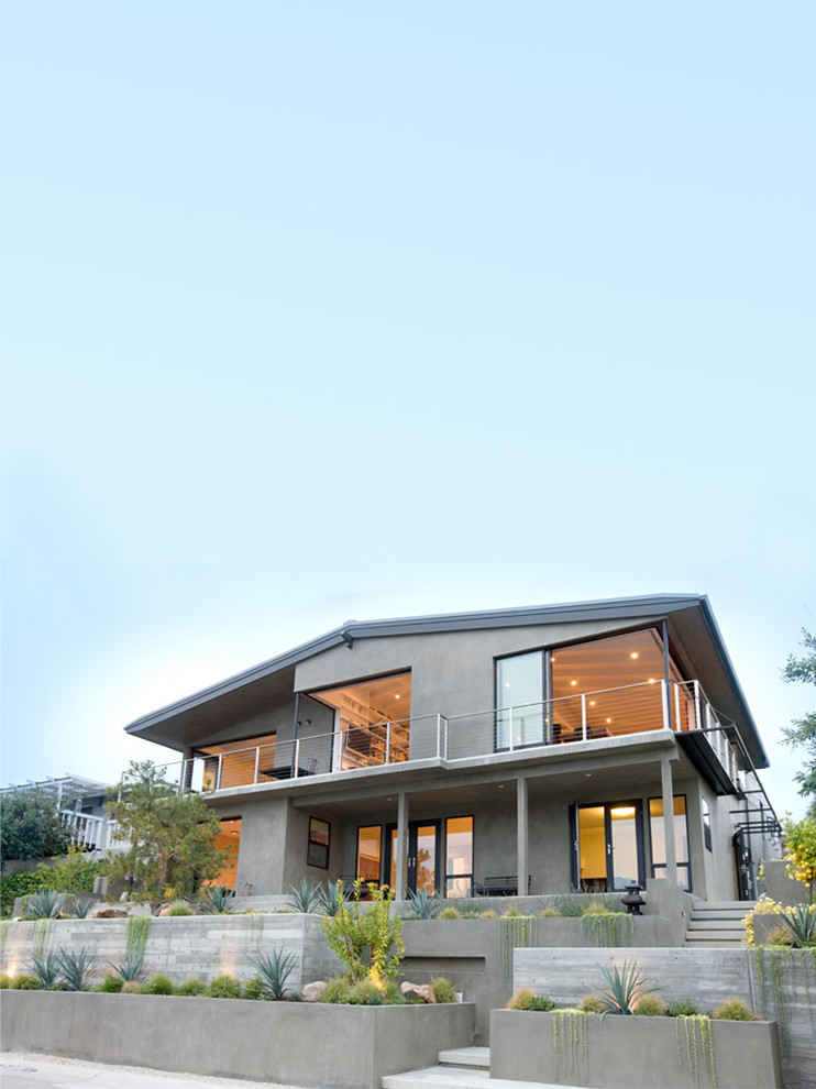 На фото: двухэтажный дом среднего размера в стиле ретро с облицовкой из бетона