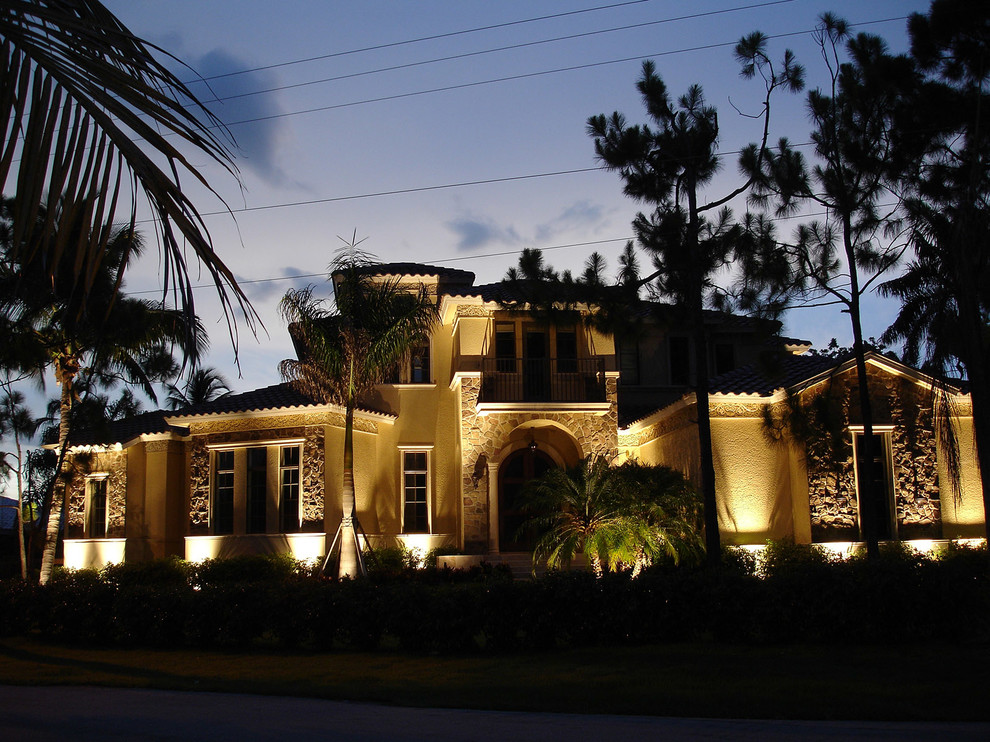 На фото: большой, двухэтажный, бежевый дом в средиземноморском стиле с комбинированной облицовкой и мансардной крышей