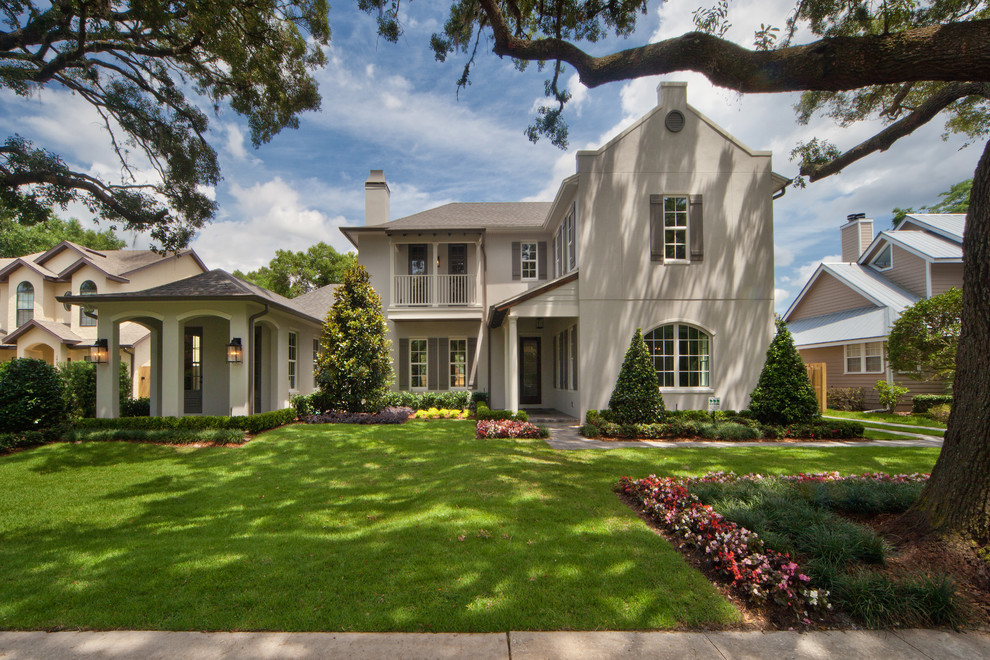 Large transitional beige two-story stucco exterior home photo in Orlando