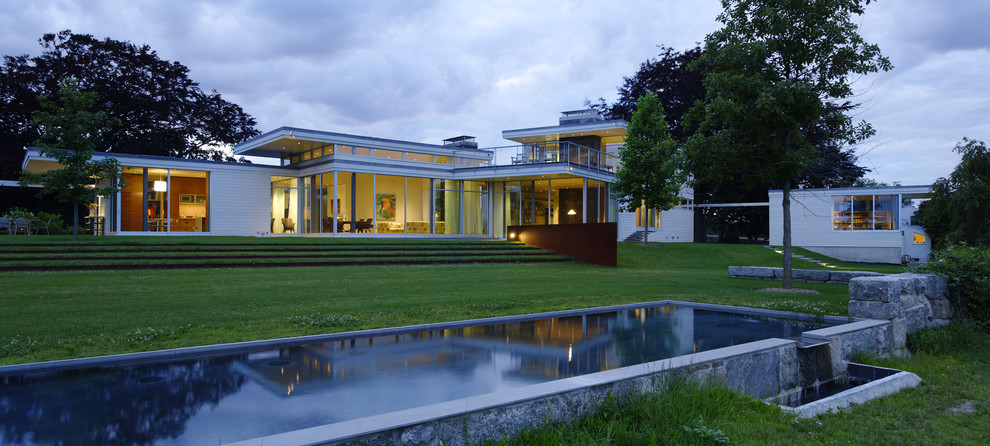 Esempio della facciata di una casa grande moderna a due piani con rivestimento in vetro