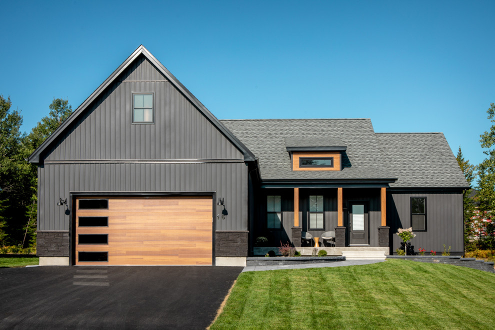 Aménagement d'une grande façade de maison noire scandinave de plain-pied avec un revêtement en vinyle, un toit à deux pans et un toit en shingle.
