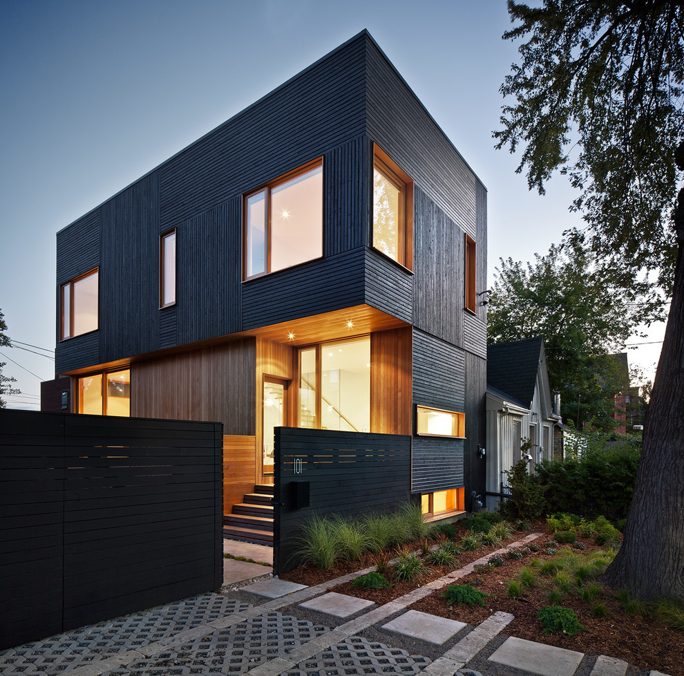 Cette image montre une petite façade de maison noire design en bois à un étage avec un toit plat.