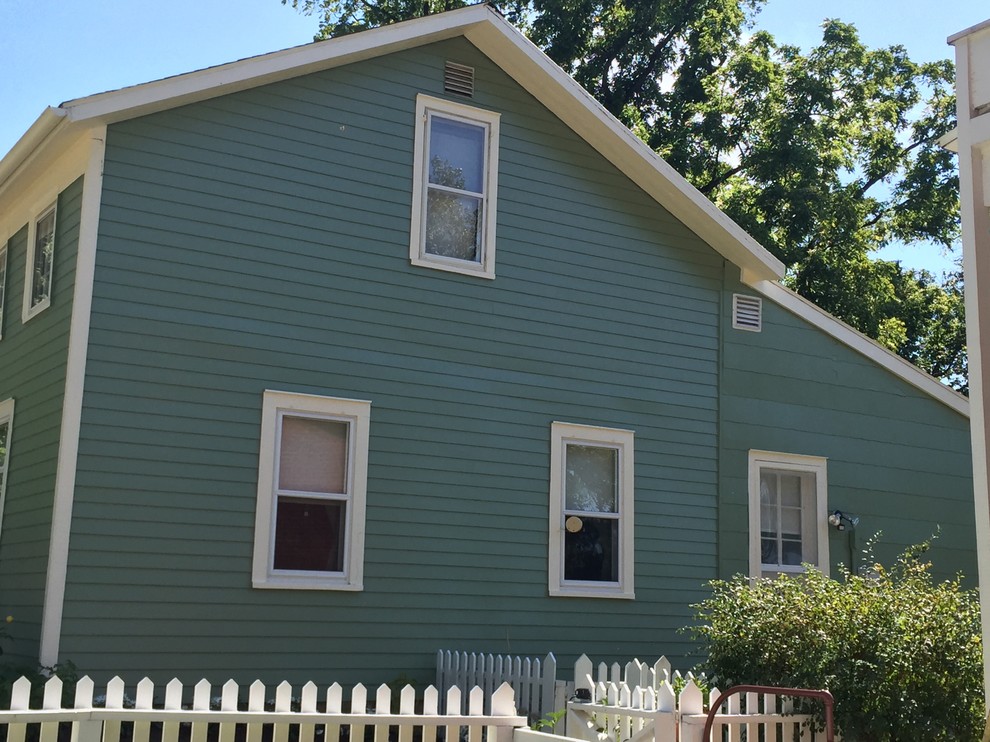 Mittelgroßes, Zweistöckiges Landhausstil Haus mit Vinylfassade, grüner Fassadenfarbe und Satteldach in Cleveland