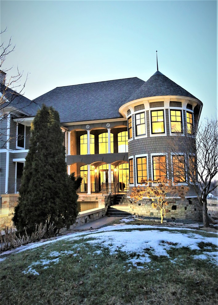 Esempio della facciata di una casa a schiera grande grigia classica a tre piani con rivestimenti misti e copertura a scandole