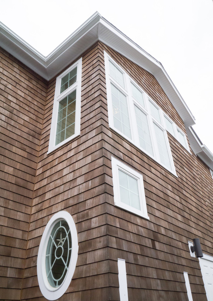 Aménagement d'une façade de maison marron bord de mer en bois de taille moyenne et à un étage.