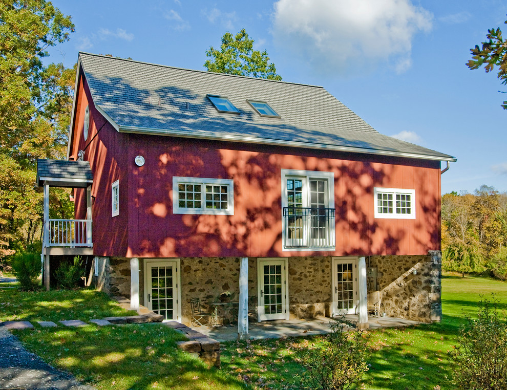Cette image montre une grande façade de maison rouge rustique en bois à deux étages et plus.