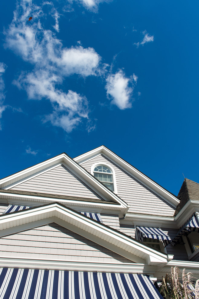 Gey and medium sized beach style house exterior in New York with three floors and mixed cladding.