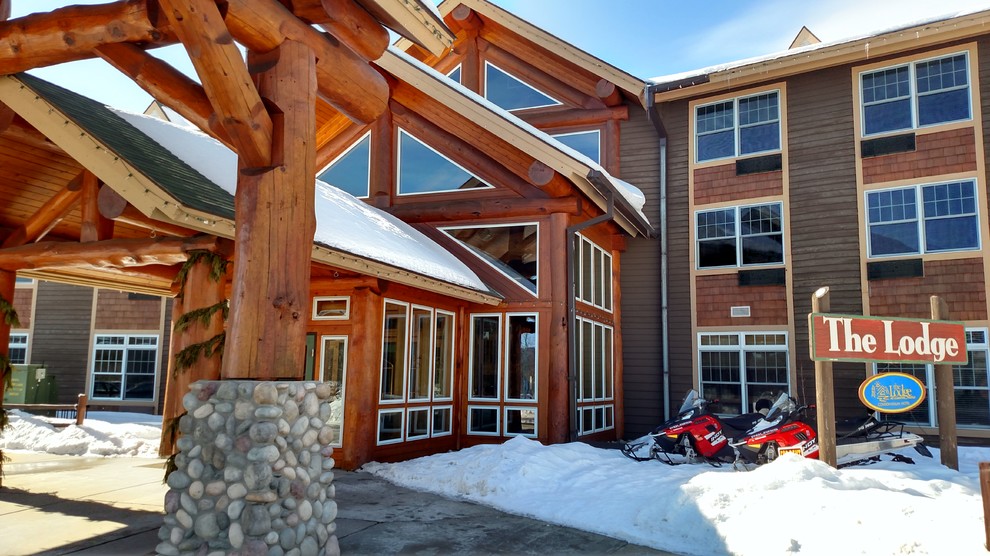 Example of a huge mountain style brown three-story wood apartment exterior design in Other with a shingle roof
