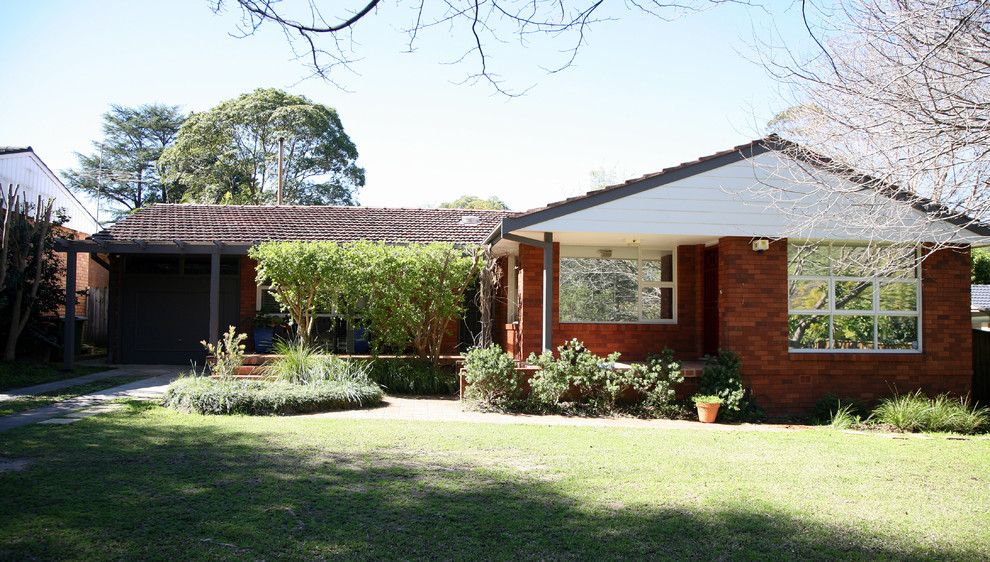 Medium sized and gey contemporary bungalow brick house exterior in Sydney with a pitched roof.