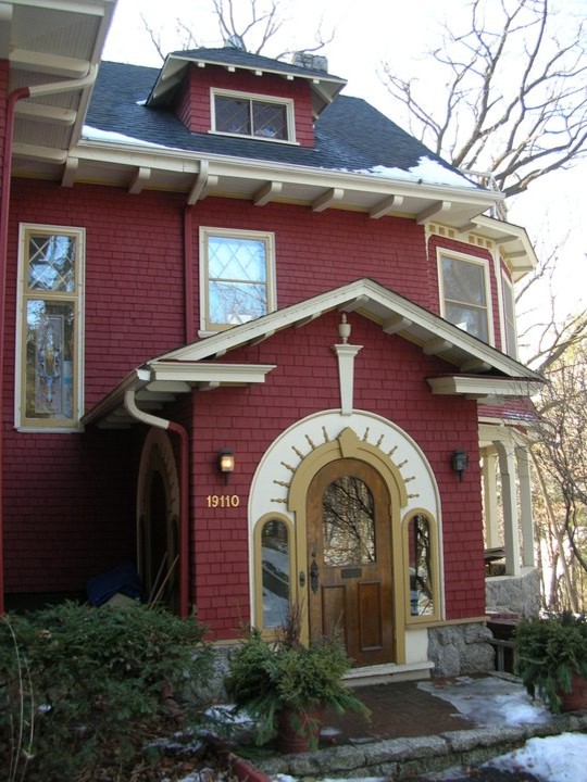 Imagen de fachada roja clásica de tamaño medio de dos plantas con revestimiento de madera