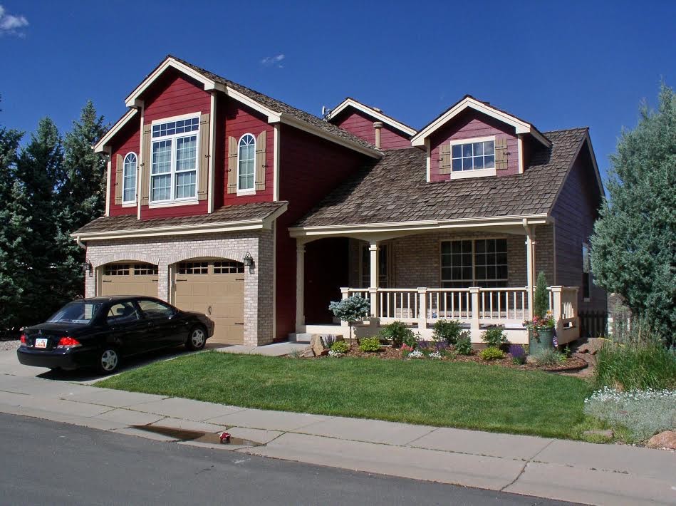 Large elegant red two-story mixed siding exterior home photo in Denver
