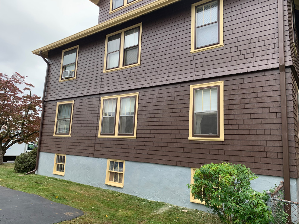 Esempio della facciata di un appartamento grande marrone classico a tre piani con rivestimento in legno, tetto a capanna e copertura a scandole