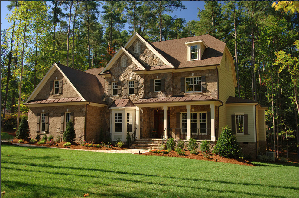 Modelo de fachada de casa marrón de estilo americano grande de dos plantas con revestimiento de piedra, tejado a doble faldón y tejado de teja de madera