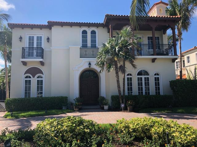 Example of a large tuscan yellow two-story stucco house exterior design in Miami with a hip roof and a tile roof