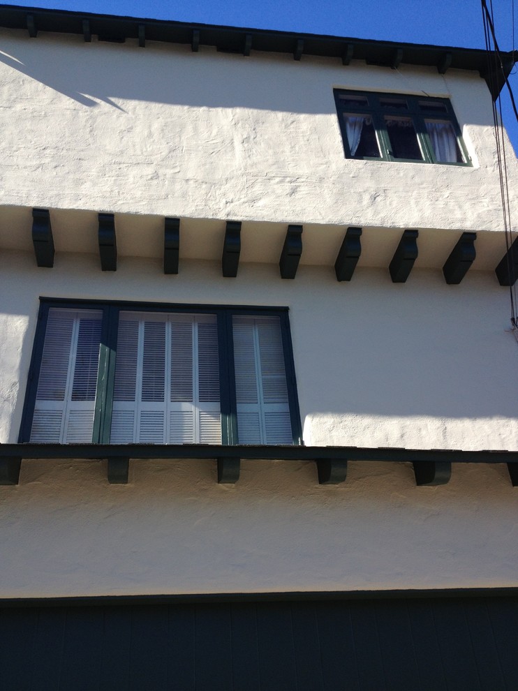 Immagine della facciata di una casa grande mediterranea a due piani con rivestimento in stucco