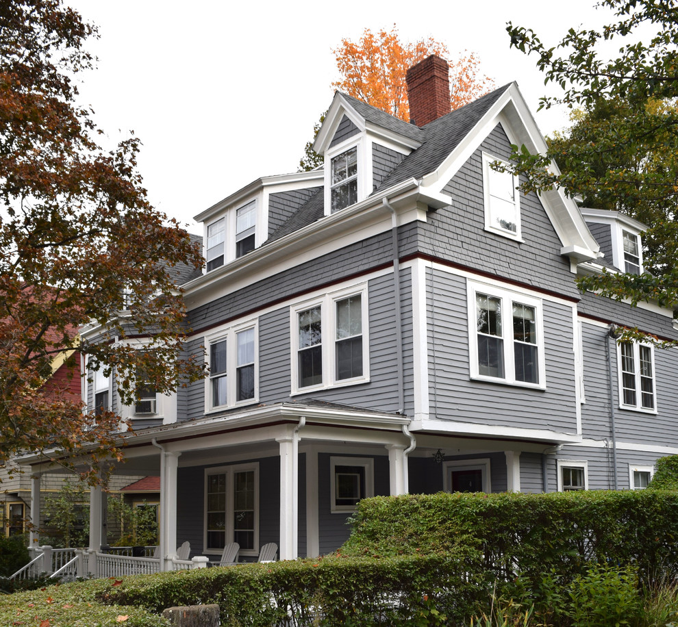 Diseño de fachada de casa gris grande de tres plantas con revestimiento de madera