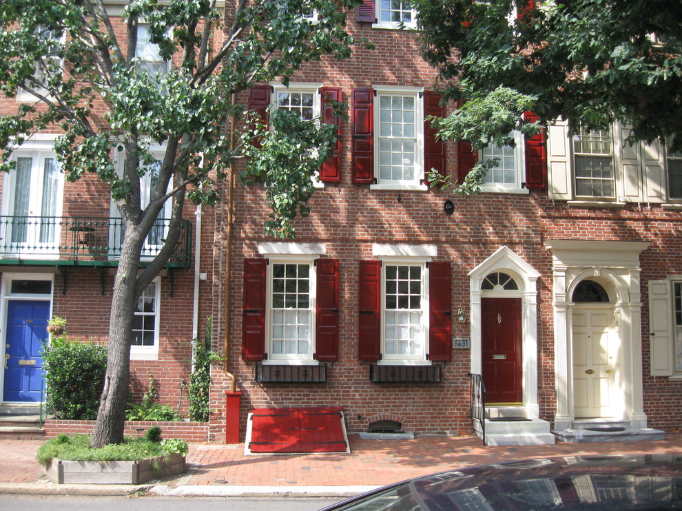 Diseño de fachada de casa pareada roja tradicional de tamaño medio de tres plantas con revestimiento de ladrillo