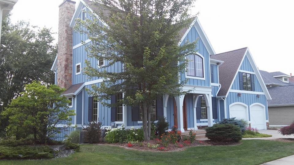 Inspiration pour une grande façade de maison bleue rustique en bois à un étage avec un toit à quatre pans.