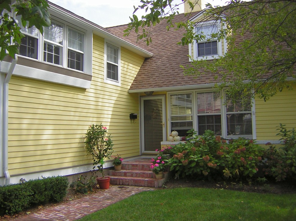Mittelgroße, Zweistöckige Shabby-Chic Holzfassade Haus mit gelber Fassadenfarbe und Satteldach in Philadelphia
